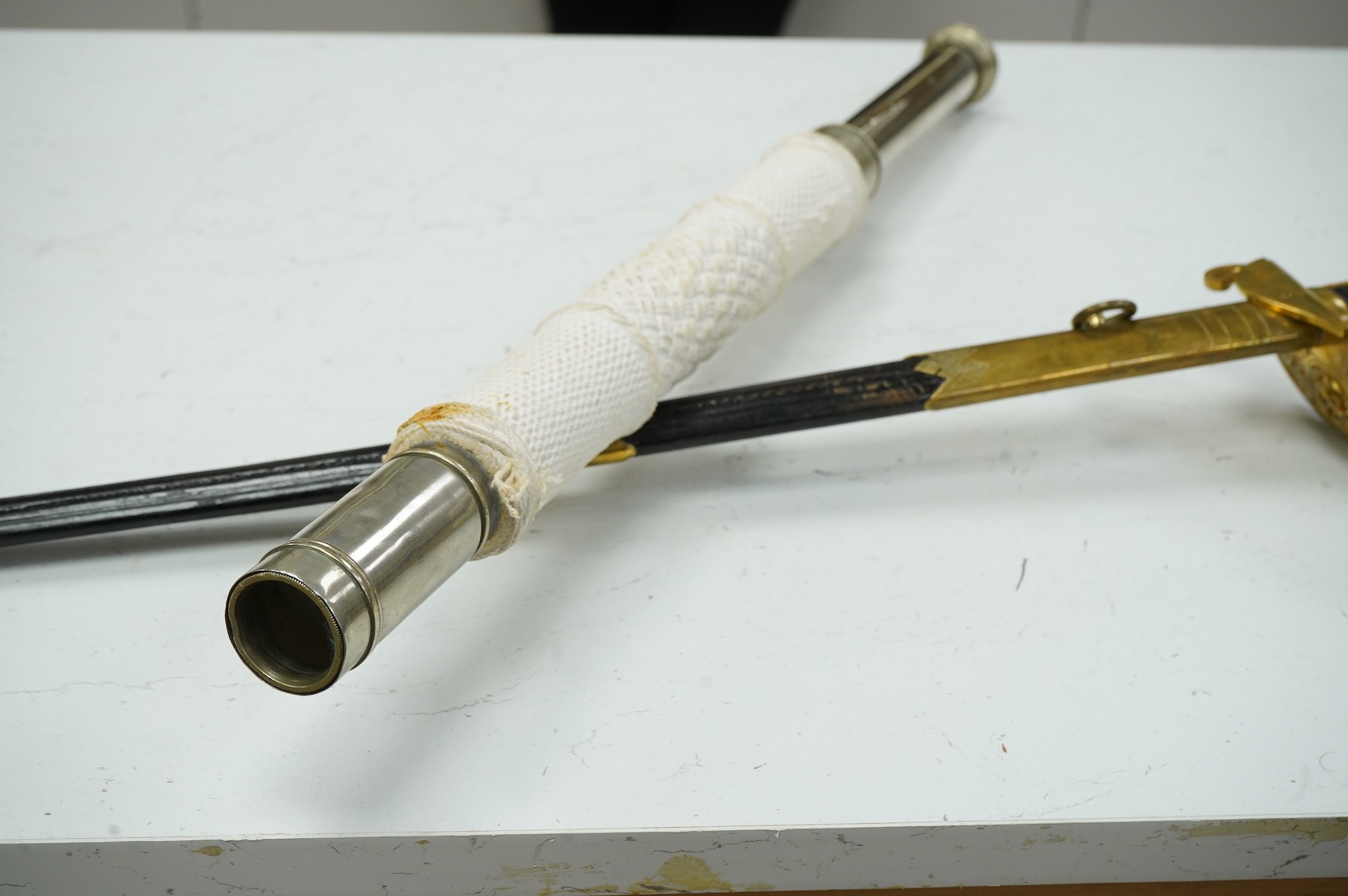 A Swedish naval officer’s presentation sword dated 1973, with regulation etched blade, gilt hilt applied with crowned fouled anchor and the three crowns of Sweden, wire bound leather covered grip, in its brass mounted le